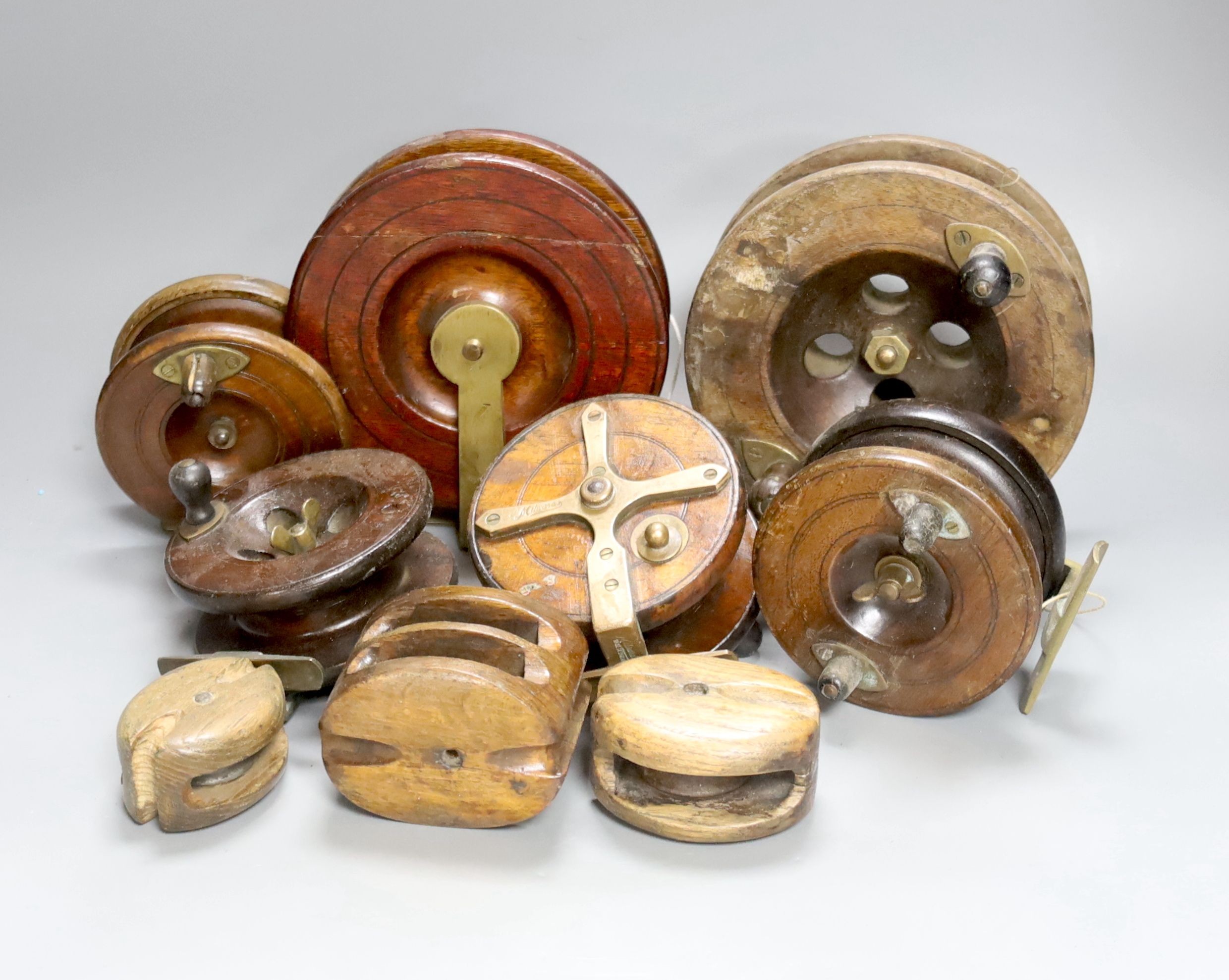 A collection of wooden fishing reels, largest diameter 16cm